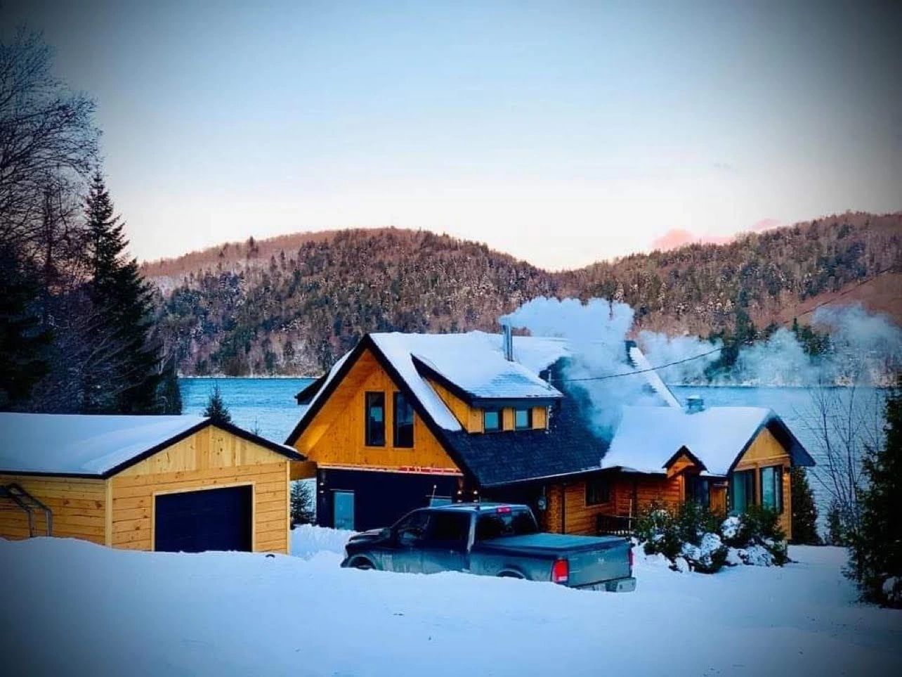 Log home in winter on the shore of a lake